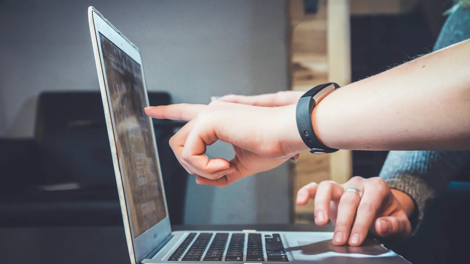 Kontrola chýb na webe malej firmy – ukazovanie na obrazovku notebooku