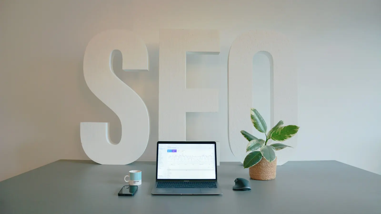 SEO audit zadarmo – nápis SEO a notebook s analýzou webu na stole